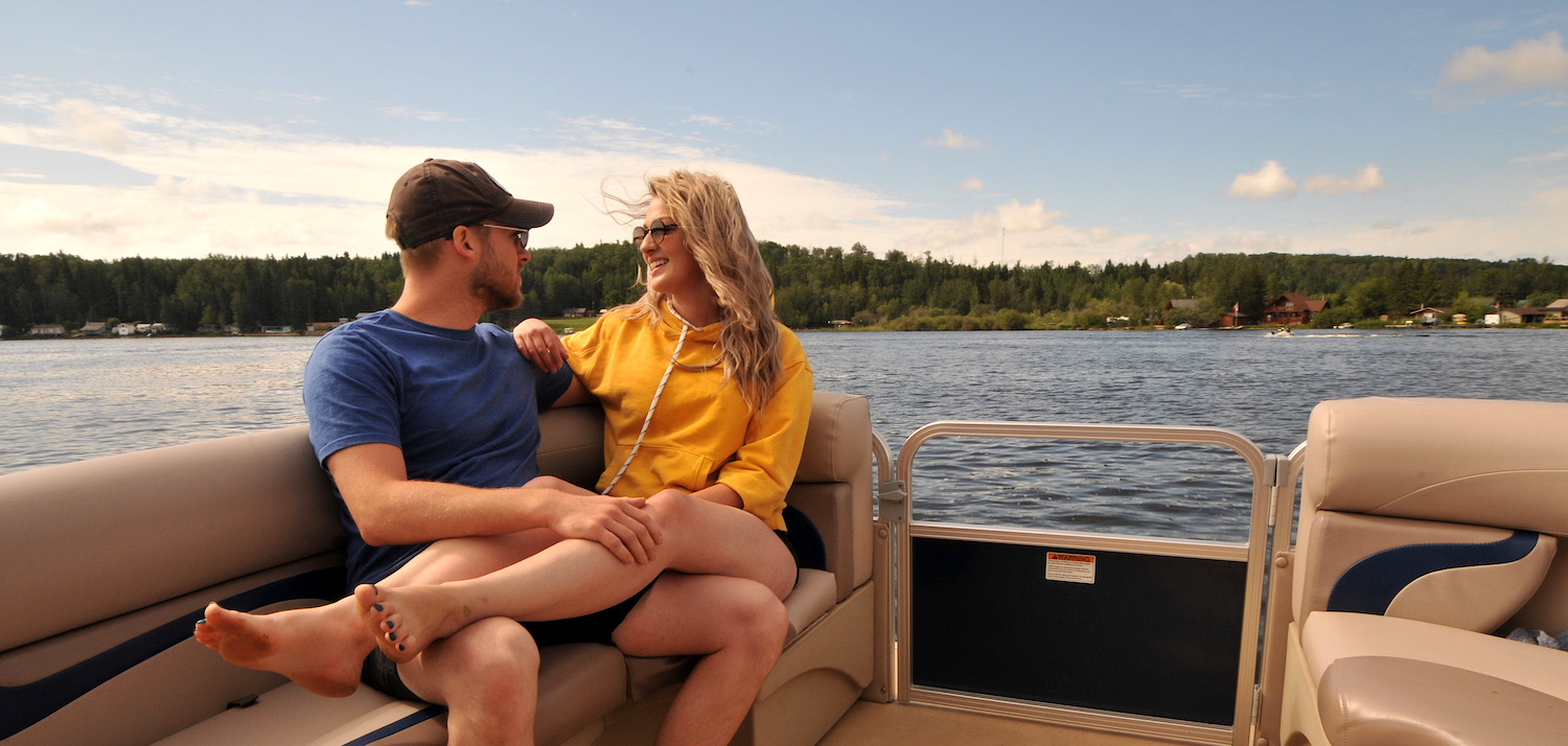 A couple cozy up on a boat on the lake in Athabasca