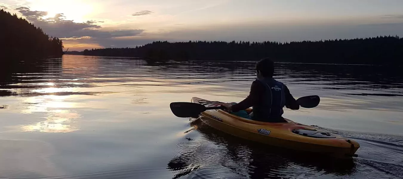 Alex kayaking over a lake at sunrise