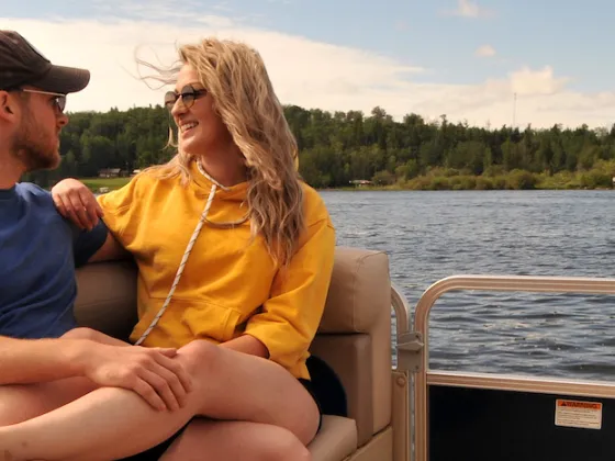 A couple cozy up on a boat on the lake in Athabasca