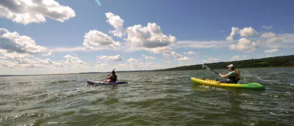 A family kayaks on the lake in MD Bonnyville