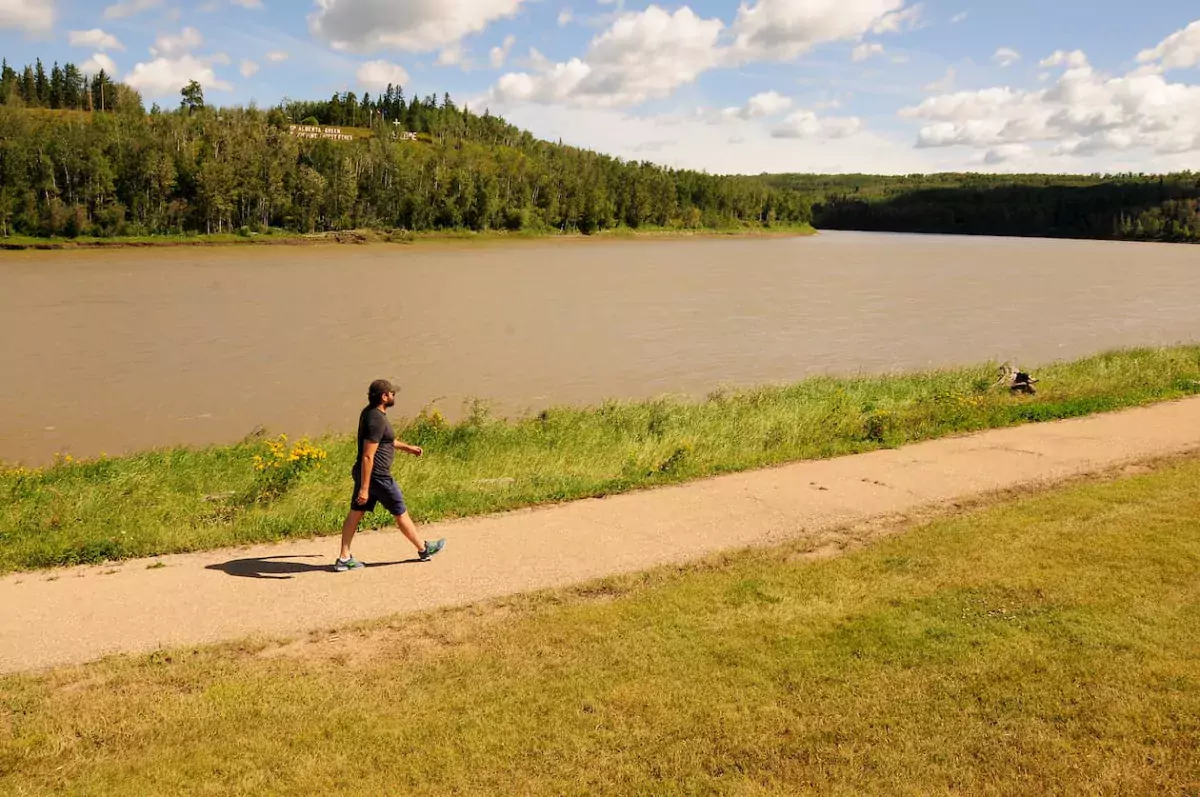A man walks along the river path in Athabasca