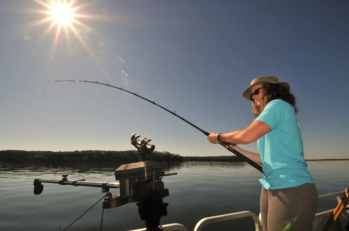 Woman fishes from a boat on Cold Lake