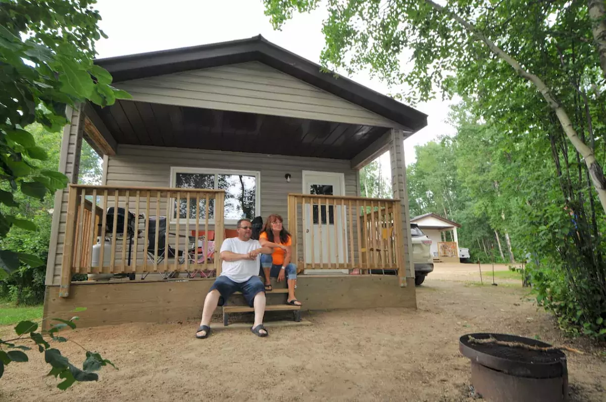 A couple relaxes on the steps of a house in Plamondon Lac La Biche