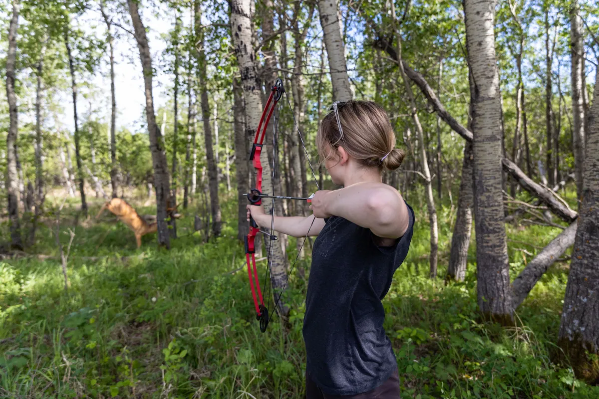 Taking aim during an archery lesson at Métis Crossing.