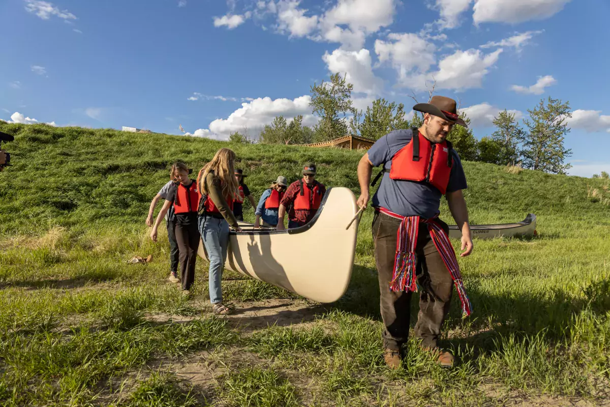 Carrying a voyageur canoe at Métis Crossing, AB.