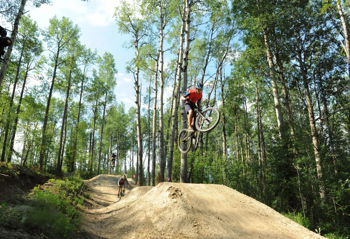 Riders taking air at the Whitecourt Bike Park, Whitecourt, AB.