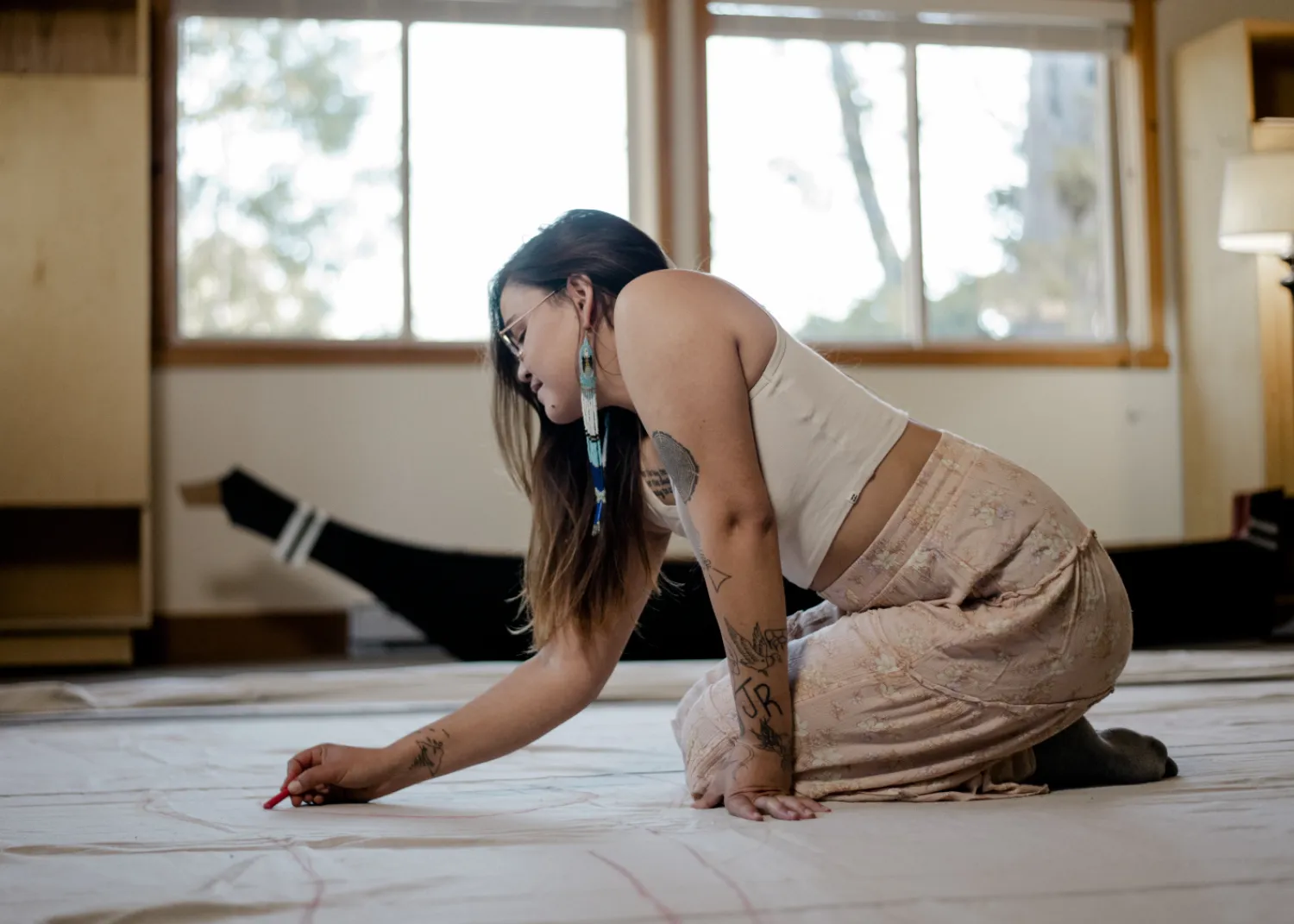 Ivy works on the large scale Tla-o-qui-aht curtains that will be on display in the Tin Wis Conference Center, one of the many highlights of the naaʔuu evenings.
