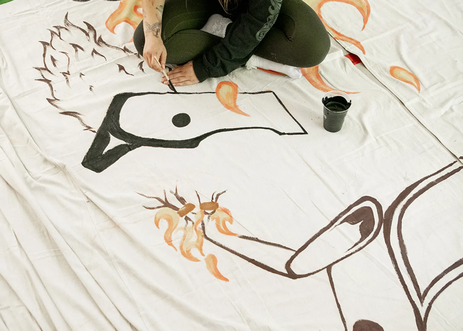 Ivy Cargill-Martin working on large scale Tla-o-qui-aht curtains that will be on display in the Tin Wis Conference Center, one of the many highlights of the naaʔuu evenings.